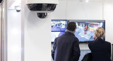 Hommes de dos devant écran de vidéosurveillance avec caméra thermique de sécurité